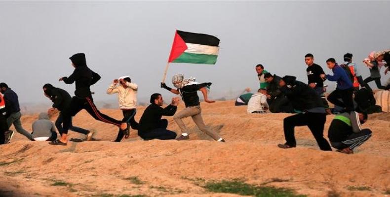 Palestinian protesters wave national flags as they participate in a demonstration on the beach near the maritime border with Israel, in the northern Gaza Strip.