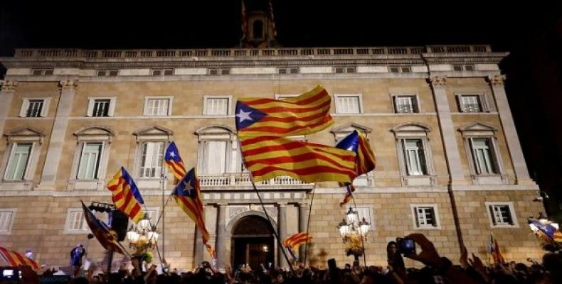 People celebrate and wave Catalan separatist flags in front of the Catalan regional government headquarters after the Catalan regional parliament declared indep