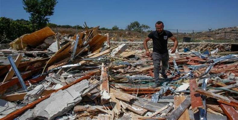 A member of a Palestinian family walks amid the rubble of their restaurant in the occupied West Bank city of Beit Jala, near Bethlehem. (Photo by AFP)