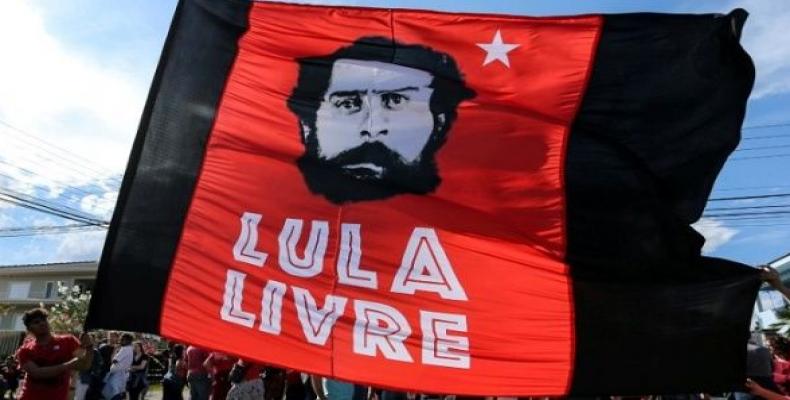 Supporters of former Brazilian President Luiz Inacio Lula da Silva hold a flag next to Federal police headquarters in Curitiba, Brazil, July 8, 2018. The flag r