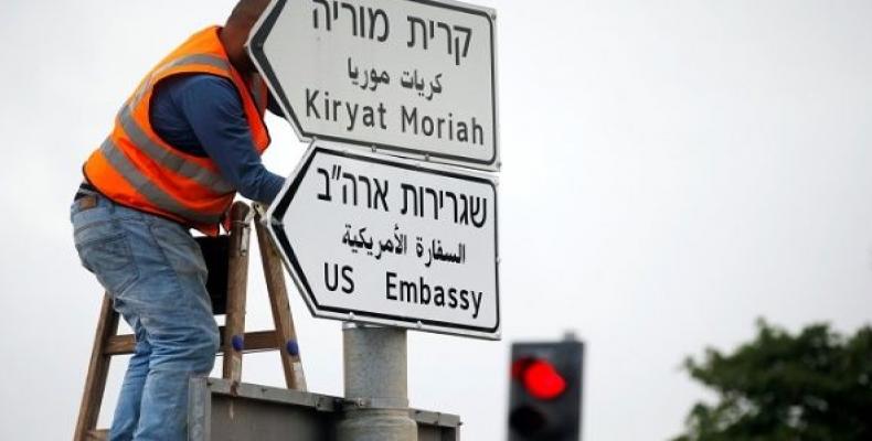 A worker hangs a road sign directing to the U.S. embassy, in the area of the U.S. consulate in Jerusalem, May 7, 2018.  Photo: Reuters