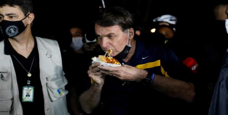 Bolsonaro come en la calle mientras le gritan asesino