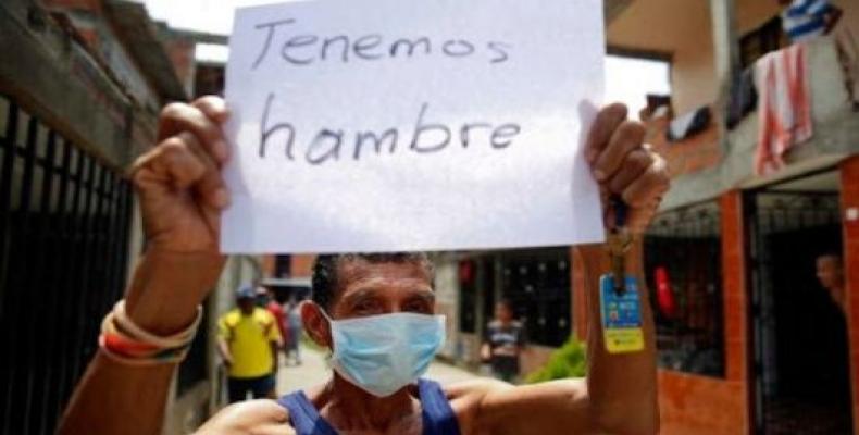 Sign reads:  &quot;Tenemos hambre.&quot;  &quot;We're hungry.&quot;