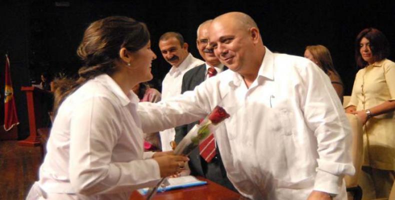 Ministro cubano de Salud Pública felicita a una de las graduadas. Foto:  Diario Granma