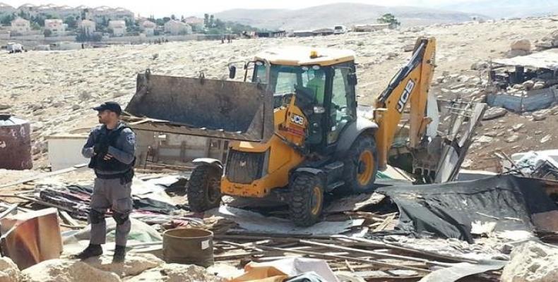 This file photo shows Israeli regime forces guarding a British company JCB's bulldozer while demolishing properties in the occupied Palestinian lands.  Photo: R