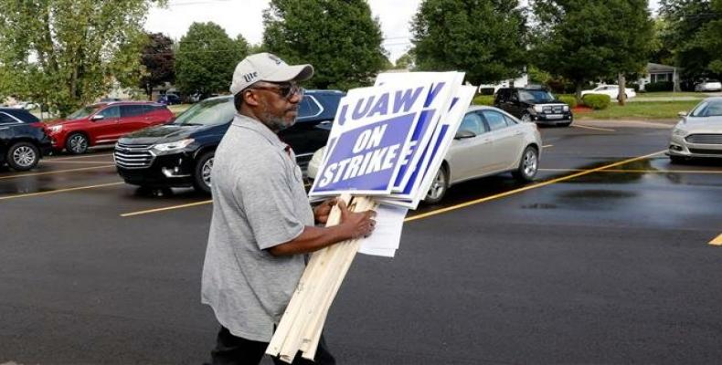 GM worker carries strike signs at the United Auto Workers (UAW) Local 163.   (Photo: AFP)