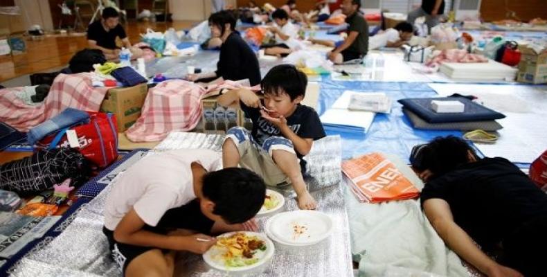 Evacuee Miyo Takeuchi, 7, eats a meal with her family at Okada elementary school, which is acting a temporary shelter for flood victims in Mabi town in Kurashik
