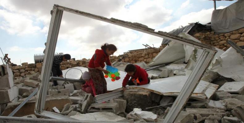 Niños palestinos buscando sus pertenencias entre los escombros de su casa demolida por Israel. (Foto/www.hispantv.com)