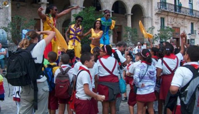 Street dancers on stilts with children in Old Havana