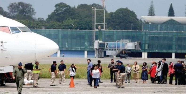 Government officials, wearing protective masks, stand next to a plane in Guatemala City.  (Photo: Luis Echeverria/Reuters)