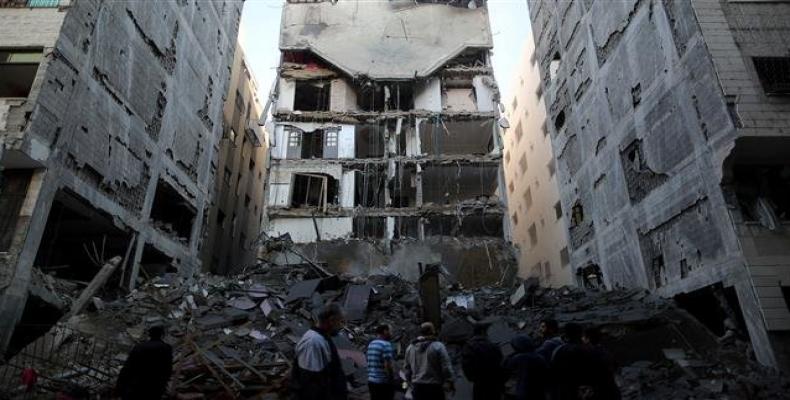 Palestinians gather near the remains of a building that was completely destroyed by an Israeli airstrike in Gaza City on November 13, 2018.  Photo: Reuters