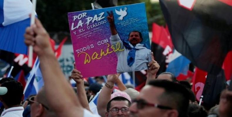 A man holds up a placard reading &quot;For Peace and Dialogue, Everyone with Daniel&quot; during May Day celebrations in Managua, Nicaragua April 30,2018.  Phot