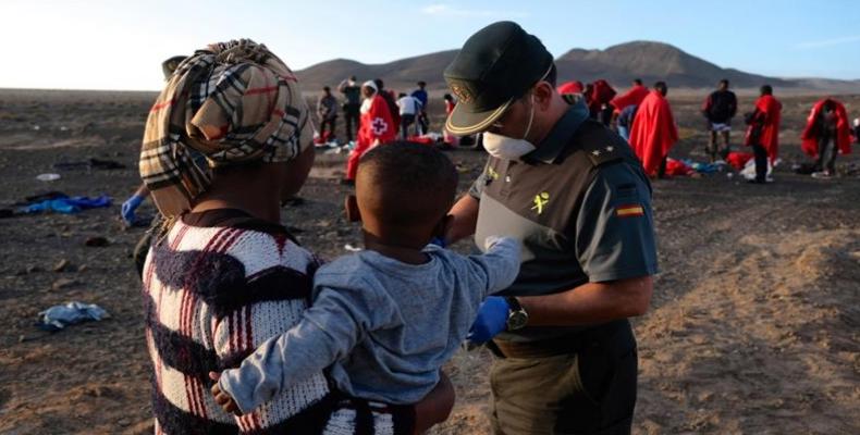 A Spanish Civil Guard officer checks migrants at Punta Salinas beach in Fuerteventura, Canary Islands.  (Photo: Carlos de Saa/EPA) 