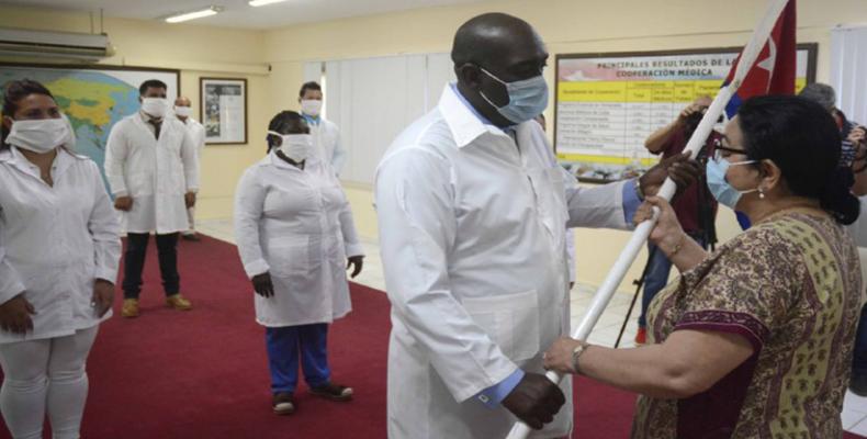 Marcia Cobas, vice-ministre de la Santé, remet le drapeau de Cuba au chef de la brigade médicale, le Dr Miguel Gómez, peu avant le départ pour le Togo.