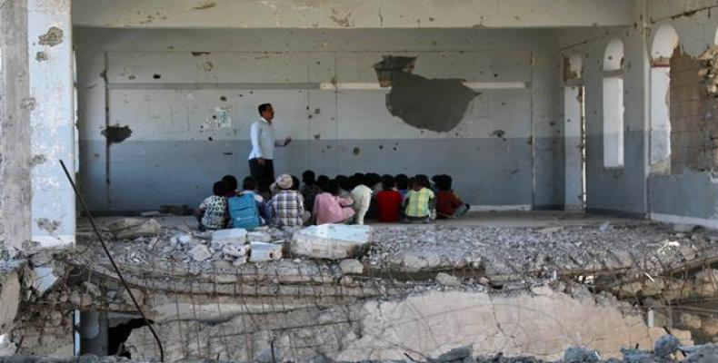 Yemeni children listen to their teacher in a destroyed classroom.  (Photo: AFP)