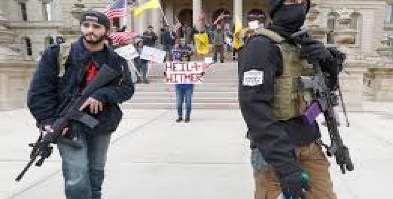 Protesters gather around Michigan State Capitol in Lansing, many armed with semi-automatic weapons.  (Photo: AFP)