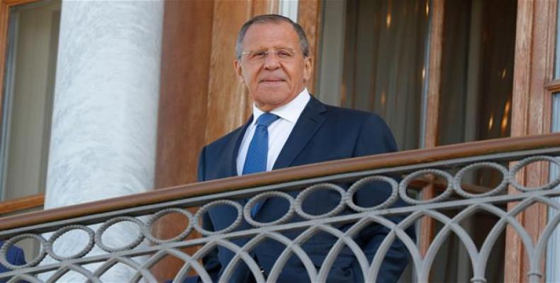 Russian Foreign Minister Sergey Lavrov stands on the balcony before a meeting of President Vladimir Putin with French President Emmanuel Macron (both not pictur