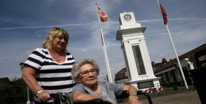 An elderly resident is wheeled past the World War 1 memorial near the civic square in the dock town of Tilbury in Essex, east of London.  Photo: AFP