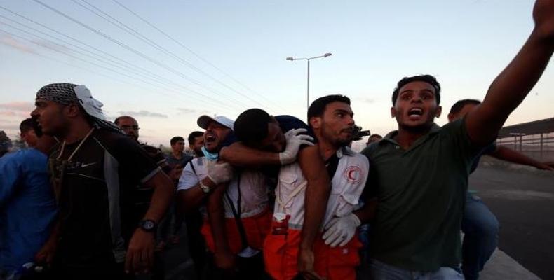 Palestinian protesters from the besieged Gaza Strip help evacuate a wounded comrade during a demonstration in northern Gaza.  Photo: AFP