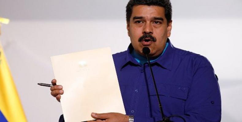 Venezuela's President Nicolas Maduro holds a document as he talks to the media before an event with supporters of Somos Venezuela (We are Venezuela) movement i
