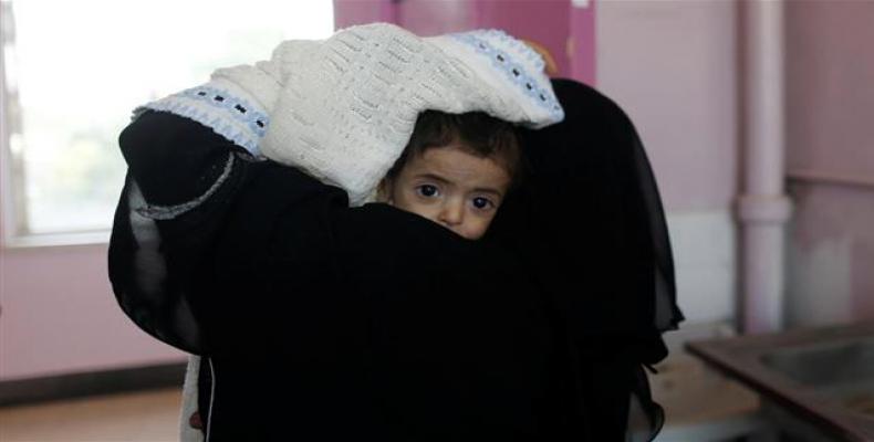 A woman carries a child at the malnutrition ward of al-Sabeen hospital in Sana'a, Yemen.  Photo: Reuters