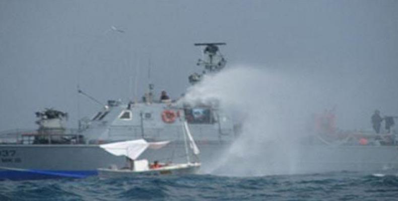 Israeli gunboat blasts water at a Palestinian fishing boat.  (Photo: PIC)