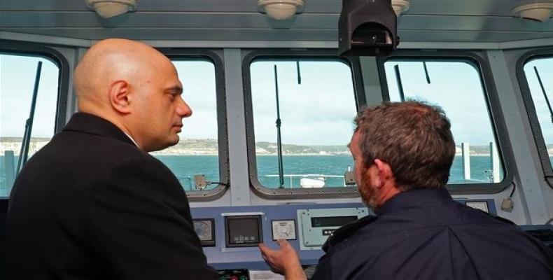 Britain's Home Secretary Sajid Javid (L) talks with UK Border Force staff onboard of Border Force cutter, HMC Searcher, on the Dover Strait off the coast of Dov
