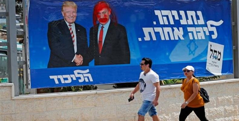 A defaced election billboard for the Likud party showing Donald Trump shaking hands with Netanyahu.  (Photo: AFP)