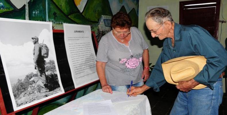 Campesino firma su compromiso con Fidel.  Foto: Diario Granma