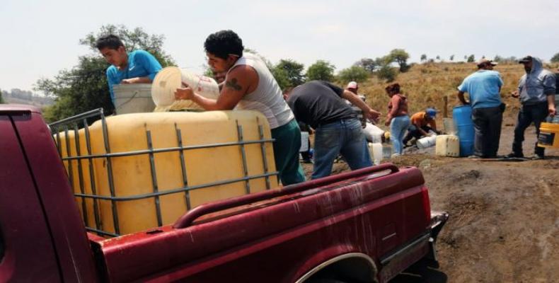 Pobladores abasteciéndose de combustible a partir de un oleoducto de Pemex.