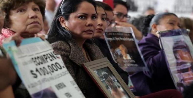 Relatives of missing persons hold signs with pictures of their loved ones. (Photo: Reuters)