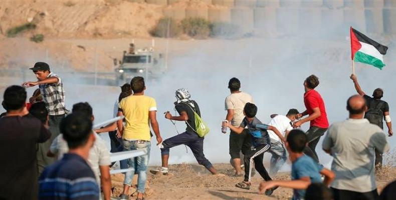 Palestinian protesters run for cover from tear gas.  (Photo by AFP)