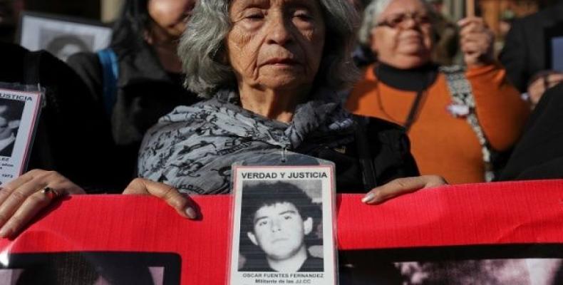 A human rights activist holds an image of a missing person during a protest against the decision of the Supreme Court to grant parole to human right abusers dur