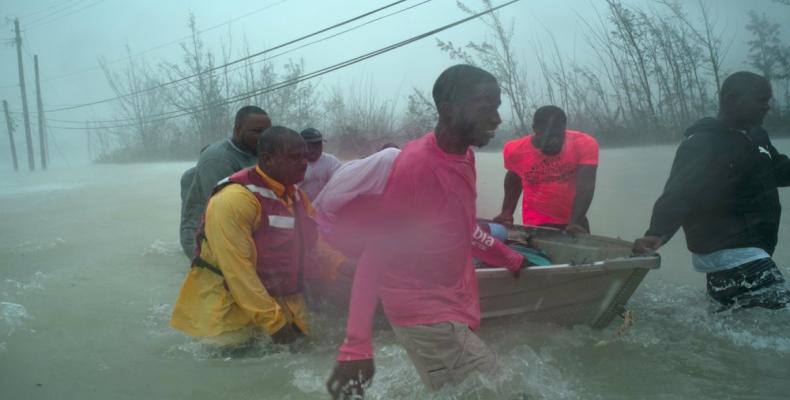 Volunteers rescue several families from the rising waters of Hurricane Dorian, near the Causarina bridge in Freeport, Grand Bahama, Bahamas, Tuesday, Sept. 3, 2