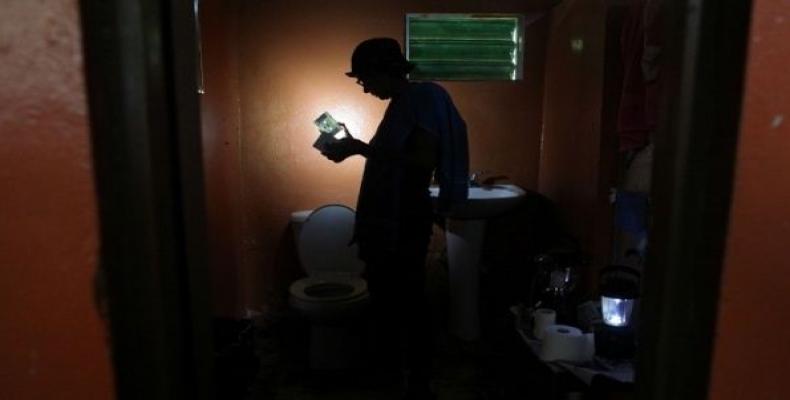 Ana Perez uses a solar lamp inside the bathroom of her home in Naguabo, Puerto Rico, on Jan. 27, 2018.  Photo: Rueters